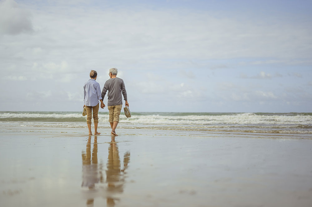 older couple strolling along beach